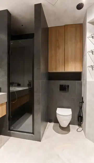 ЖК «Дом NV/9». Рядом с раковиной раздвижная дверь из тонированного стекла