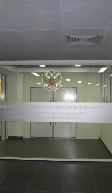 Стеклянные двери главного прохода в фойе с гербом Российской Федерации
