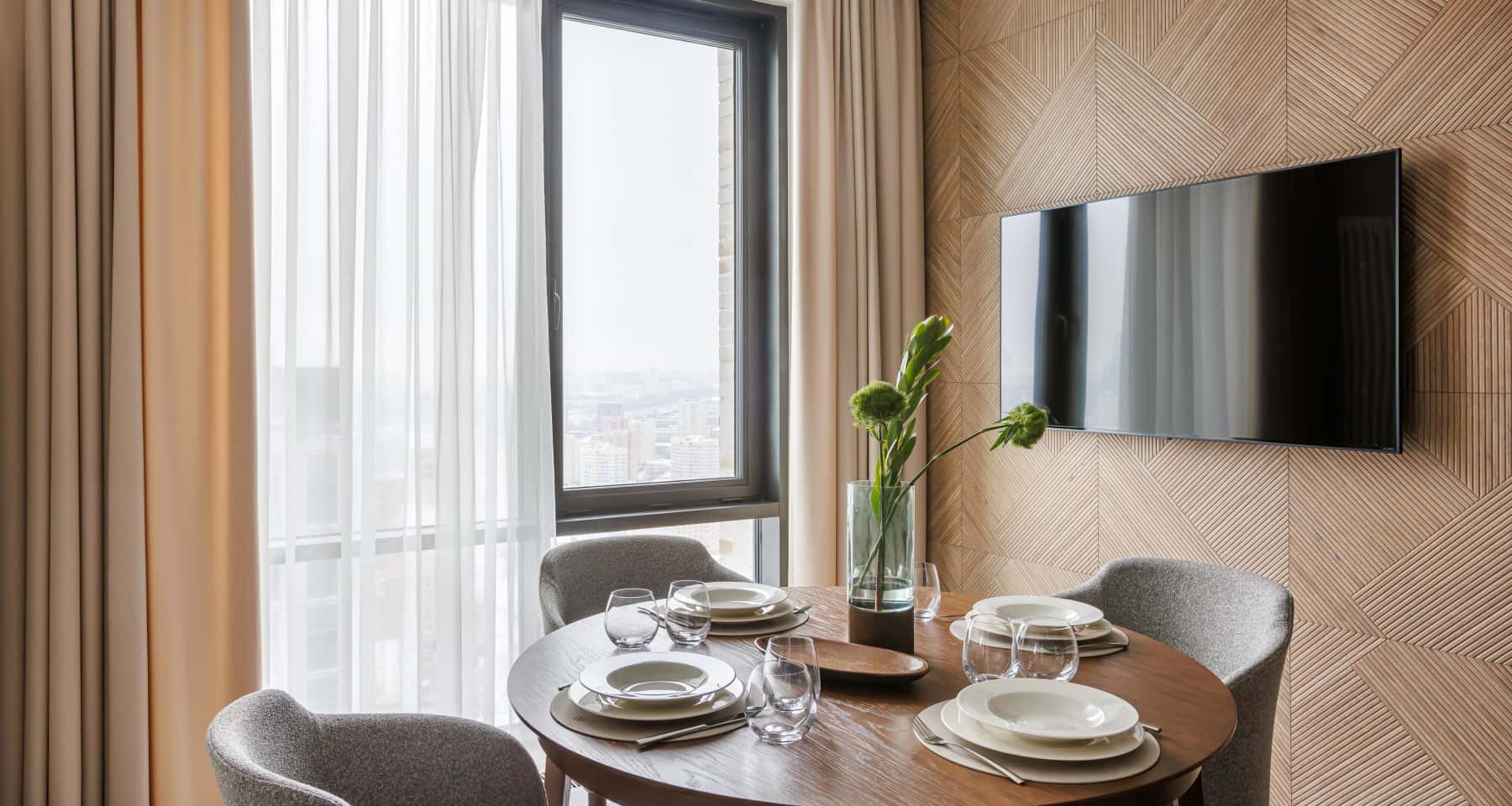 Обеденный стол у окна с видом на город