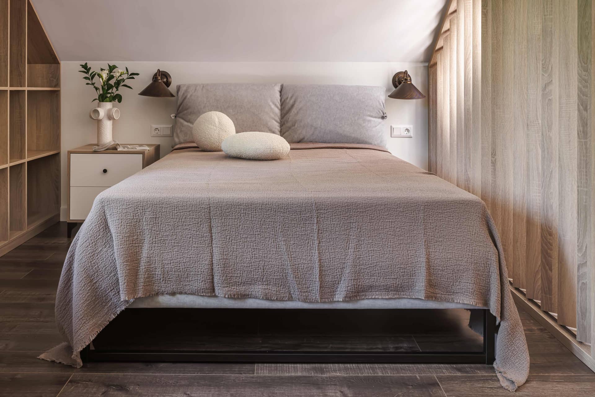 Парные бра в изголовье кровати уравновешивают асимметричную компоновку мебели