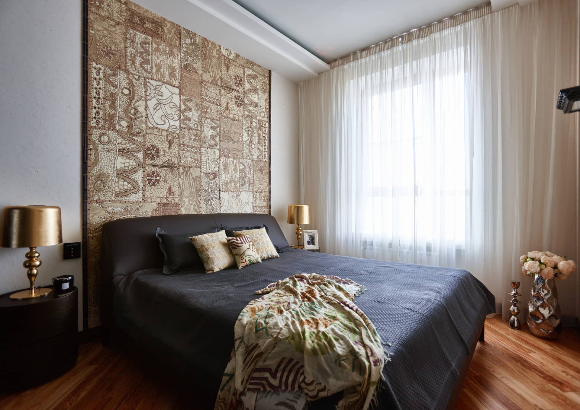 В спальне главная стенка обрамлена тканью из шёлка с рисунками