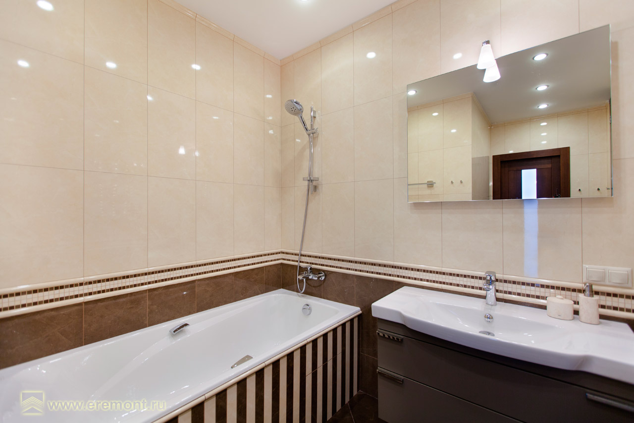 Ванная комната выполнена из плитки кремового и светло-коричневого цветов