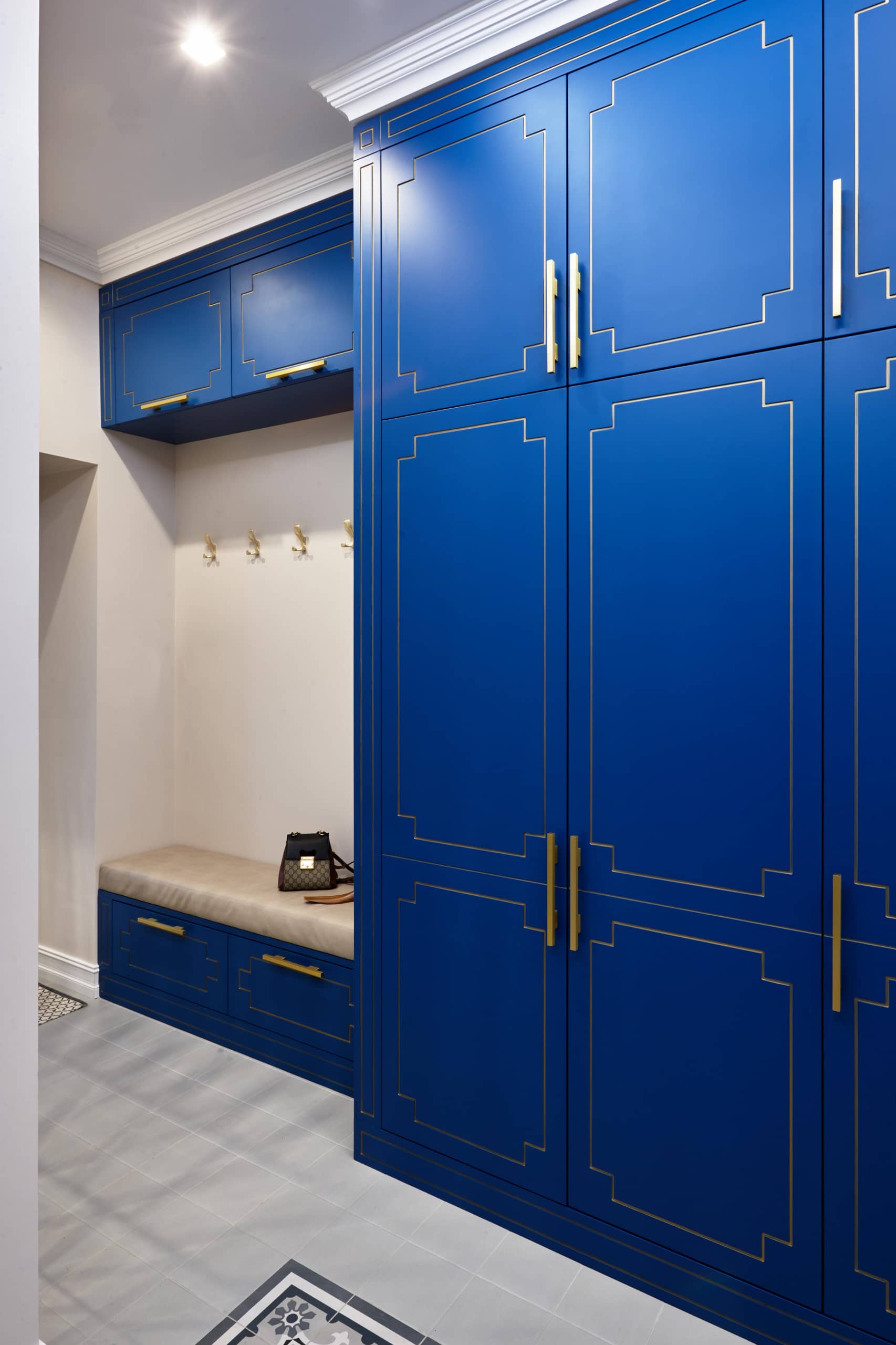 Просторный шкаф синего цвета с банкеткой в прихожей
